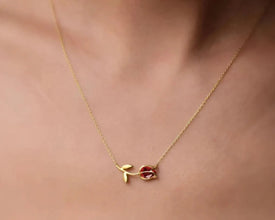 Close-up of a tulip-shaped silver pendant with a vibrant garnet gemstone accent.