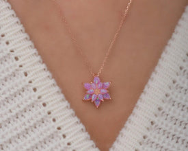 A sterling silver lotus flower necklace with an elegant pink opal gemstone, symbolizing balance and renewal.