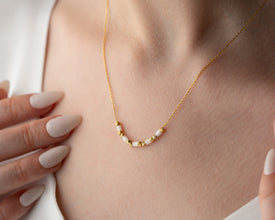 Detail shot of sparkling white gemstone and gold beads