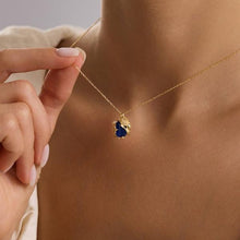 Gold necklace with a blue pendant being worn
