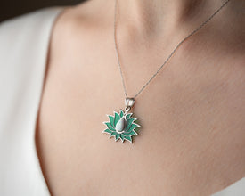 Handmade stained glass jewelry piece with floral and cosmic inspiration, glowing in natural light.