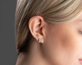 A pair of delicate silver bird-shaped stud earrings, symbolizing freedom and adventure.