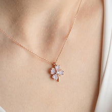 Rose gold necklace with a floral pendant on a person's neck