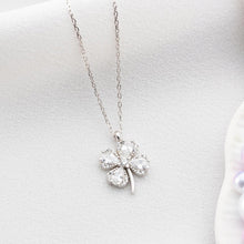 Silver necklace with a clover-shaped pendant on a white background