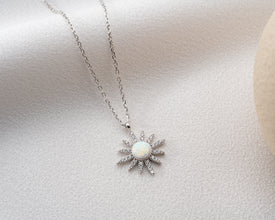 A cosmic-inspired silver necklace layered with other celestial jewelry for a complete look.