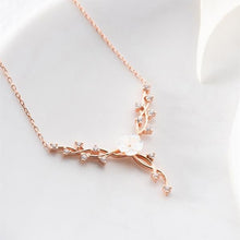 Rose gold necklace with pearl-like beads on a light background