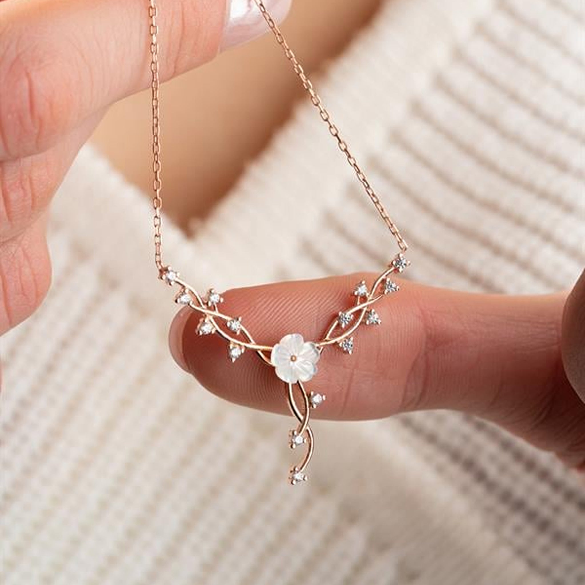 Close-up of magnolia ivy vine pendant necklace crafted in 925 sterling silver with zircon stones on white background.