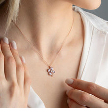 Necklace with a pink flower pendant worn by a person