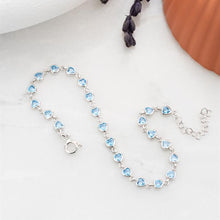 Silver bracelet with heart-shaped blue stones on a white surface