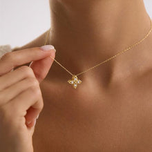 Gold necklace with a star-shaped pendant being adjusted on a person's neck.