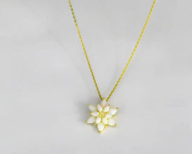 A close-up of a handmade sterling silver lotus pendant, showcasing intricate details.