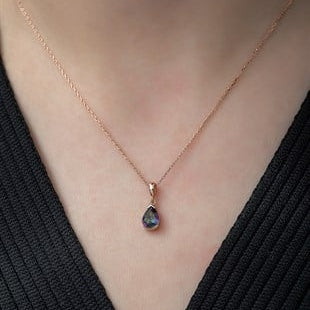 Necklace with a teardrop-shaped pendant on a person wearing a black top.