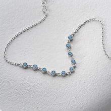 Silver bracelet with blue gemstones on a light gray background