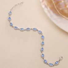 Silver bracelet with blue gemstones on a beige background