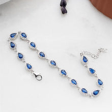 Silver bracelet with blue gemstones on a white background