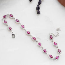 Silver bracelet with pink gemstones on a white surface