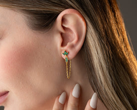 Mother and daughter wearing matching gold lotus earrings while hugging