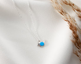 Delicate opal gemstone bird charm in a nature-inspired necklace design.