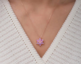 Nature-inspired spiritual jewelry featuring a lotus pendant with a glowing fire opal gemstone.