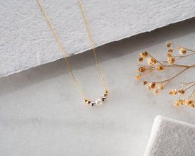 Side profile showing length and drape of pearl necklace