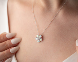 Artistic handmade floral jewelry featuring a delicate blooming flower design with an opal gemstone.