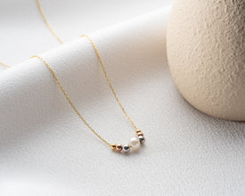 Lifestyle photo of minimalist pearl necklace outdoors