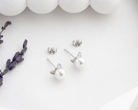 Cat-shaped earrings on a white background with decorative elements.