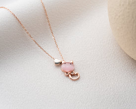 Necklace on a display bust showing silver and pink design