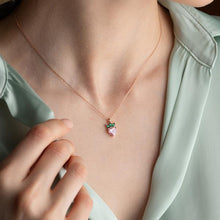 Necklace with a strawberry pendant worn by a person