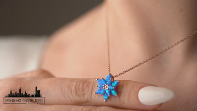 Close-up of a sterling silver lotus pendant with blue opal stone