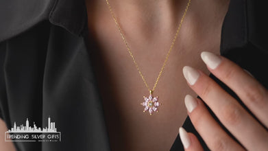 Close-up of a blooming magnolia pendant crafted in sterling silver, featuring a soft pink tourmaline center.