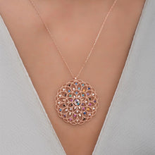 Rose gold necklace with a colorful pendant on a neutral background