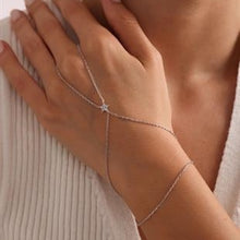 Silver bracelet on a wrist with a neutral background