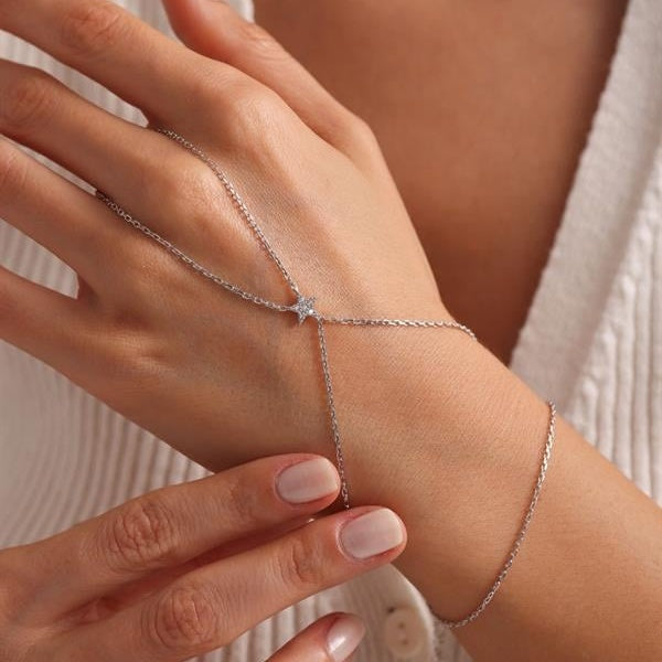 Silver bracelet on a wrist with a delicate chain design.