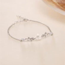 Silver bracelet with floral design on a light background