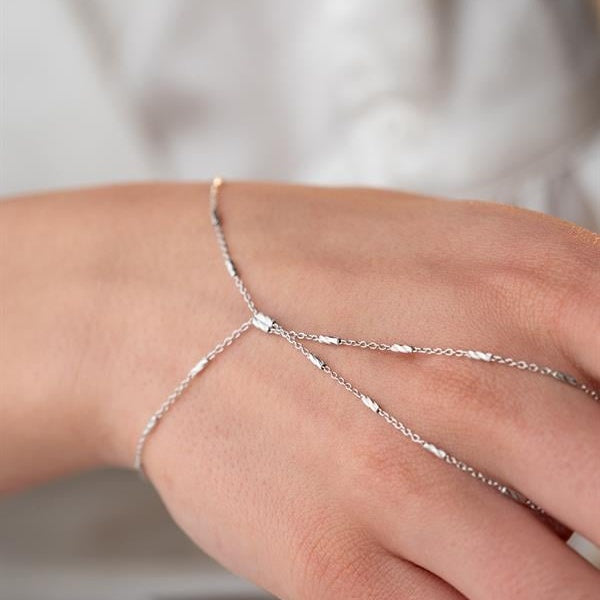 Silver chain bracelet on a wrist with a blurred background