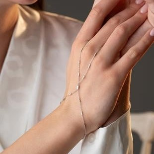 Close-up of a hand wearing a delicate bracelet with a blurred background