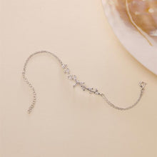 Silver bracelet with floral design on a beige background