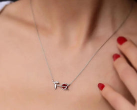 Romantic floral pendant necklace with a rich red garnet stone for women.