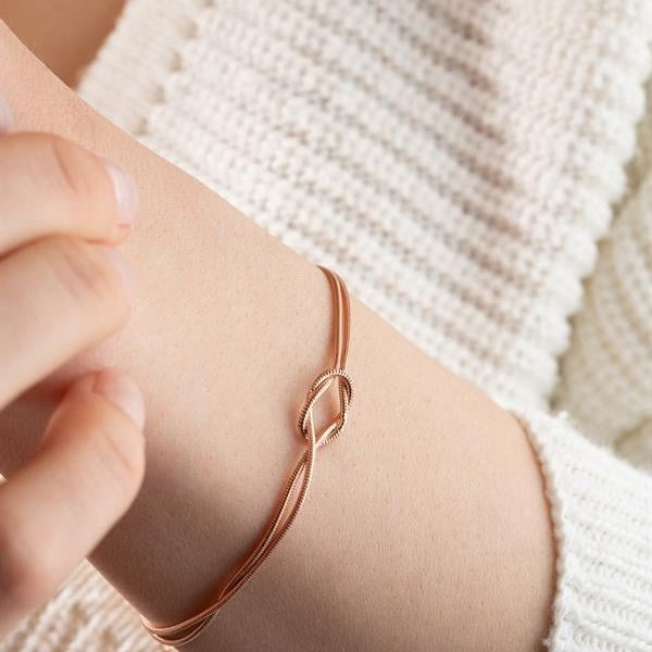 Rose gold bracelet on a wrist with a blurred background