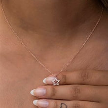 Rose gold necklace with a star pendant worn by a person.