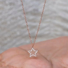 Rose gold star-shaped pendant necklace on a blurred background