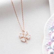 Rose gold necklace with a clover-shaped pendant on a light background
