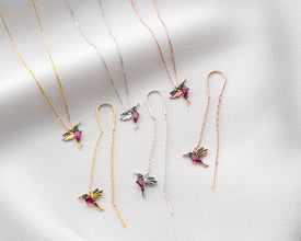 Close-up of handcrafted sterling silver hummingbird necklace and earrings symbolizing joy and freedom