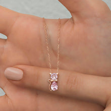 Rose gold cat-shaped necklace with a pink gemstone on a hand