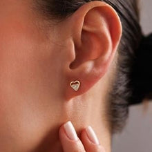 Heart-shaped earring worn by a person