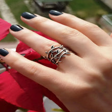 A silver adjustable leaf vine ring displayed on a modelÕs hand, showing its delicate nature-inspired design with detailed leaves and open band.