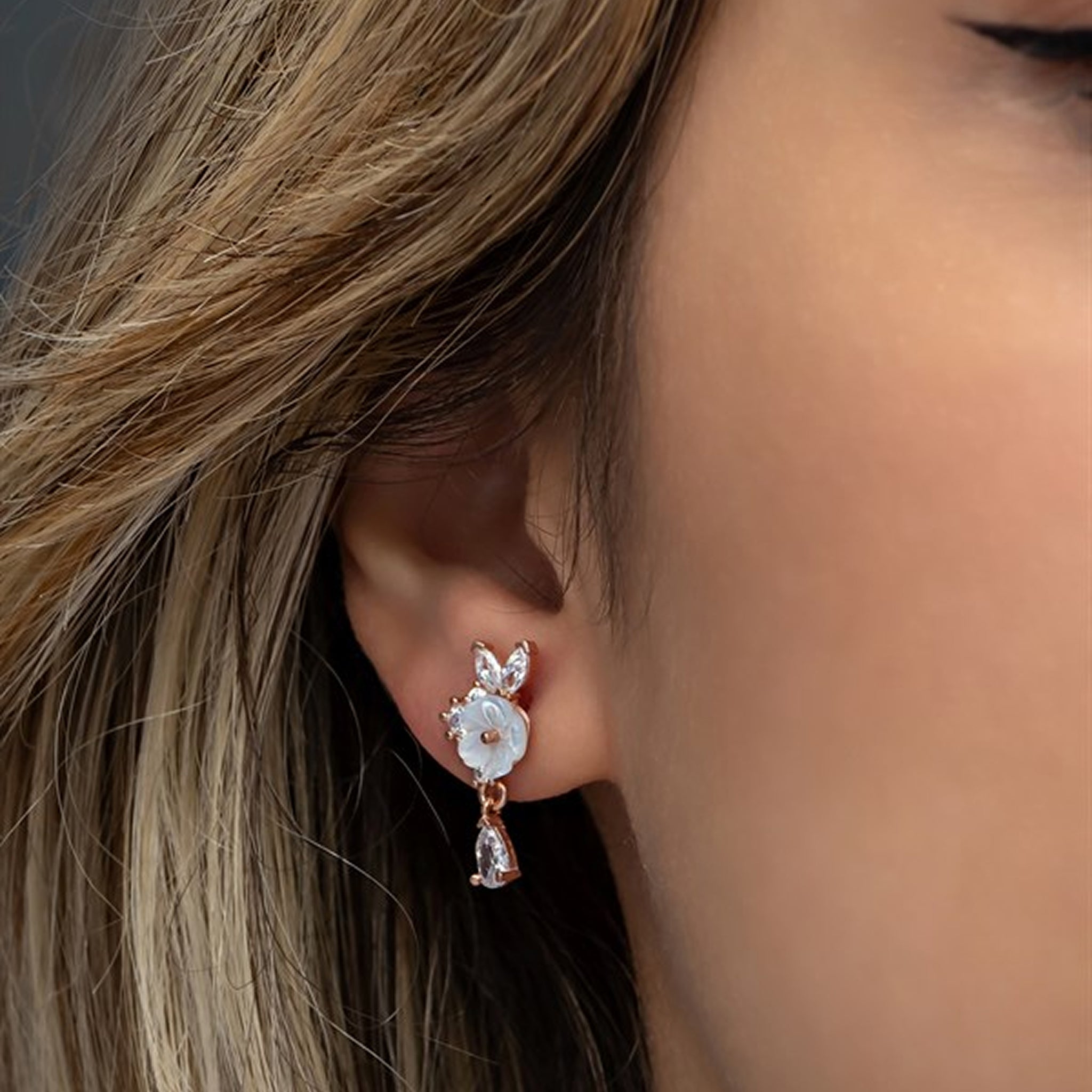 Close-up of an ear wearing a delicate earring with a blurred background