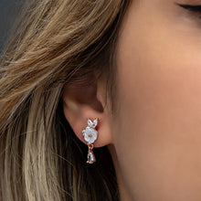 Close-up of an ear wearing a delicate earring with a blurred background