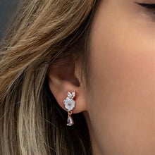 Close-up of an ear wearing a diamond earring with a blurred background